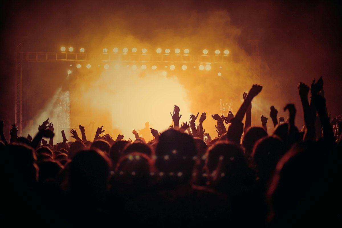A crowd under stage lights, shown in grey